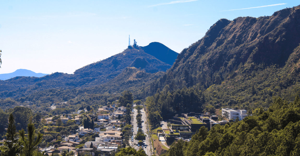Vista do Mirante da Serra do Curral do Maganbeira, com árvores, avenida e casas em BH