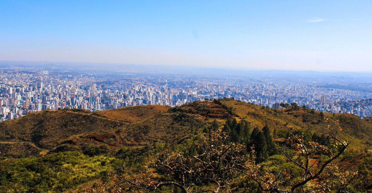 Vista do Mirante da Serra do Curral, com a cidade de Belo Horizonte no fundo, montanhas e céu azul