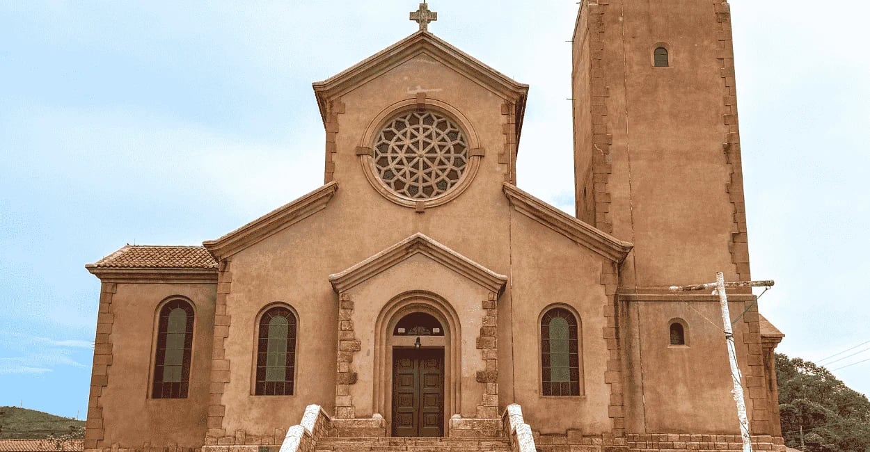 Igreja Matriz de Miguel Burnier vista de frente, com rosácea, torre lateral e escadaria na entrada