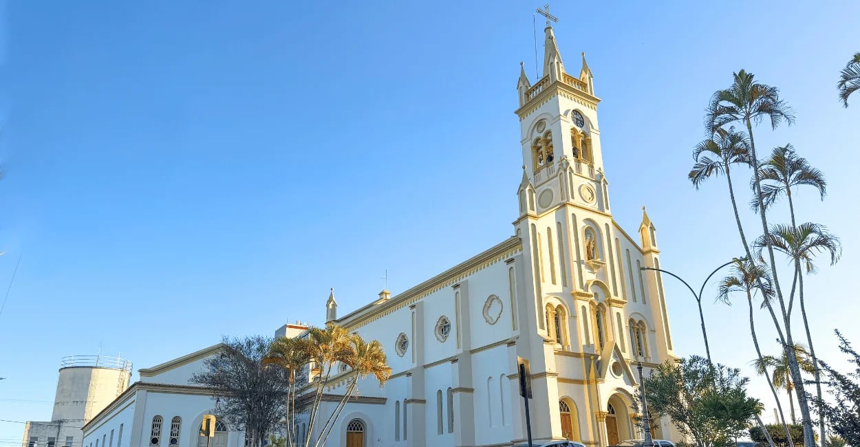 Vista lateral da Igreja Matriz de Carmópolis de Minas sob céu azul