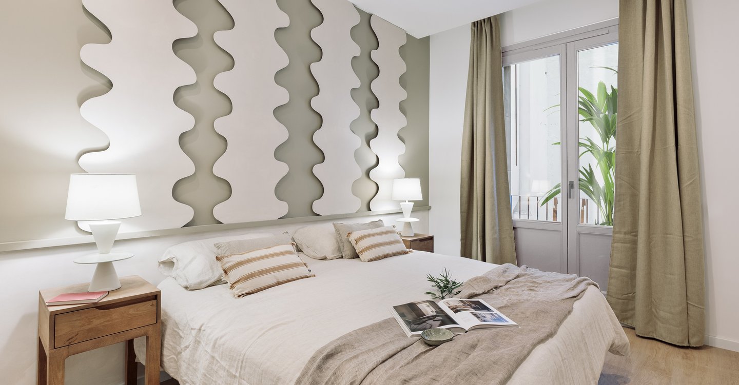 Calm bedroom design with neutral tones, natural materials, and a wavy panel headboard