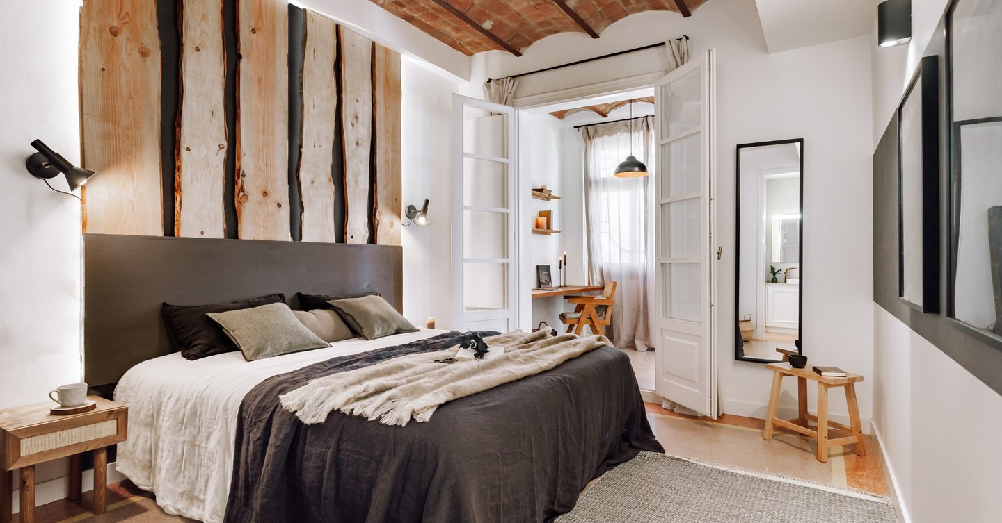 Elegant bedroom design with custom designed headboard wood panels, rustic decor and vaulted ceiling