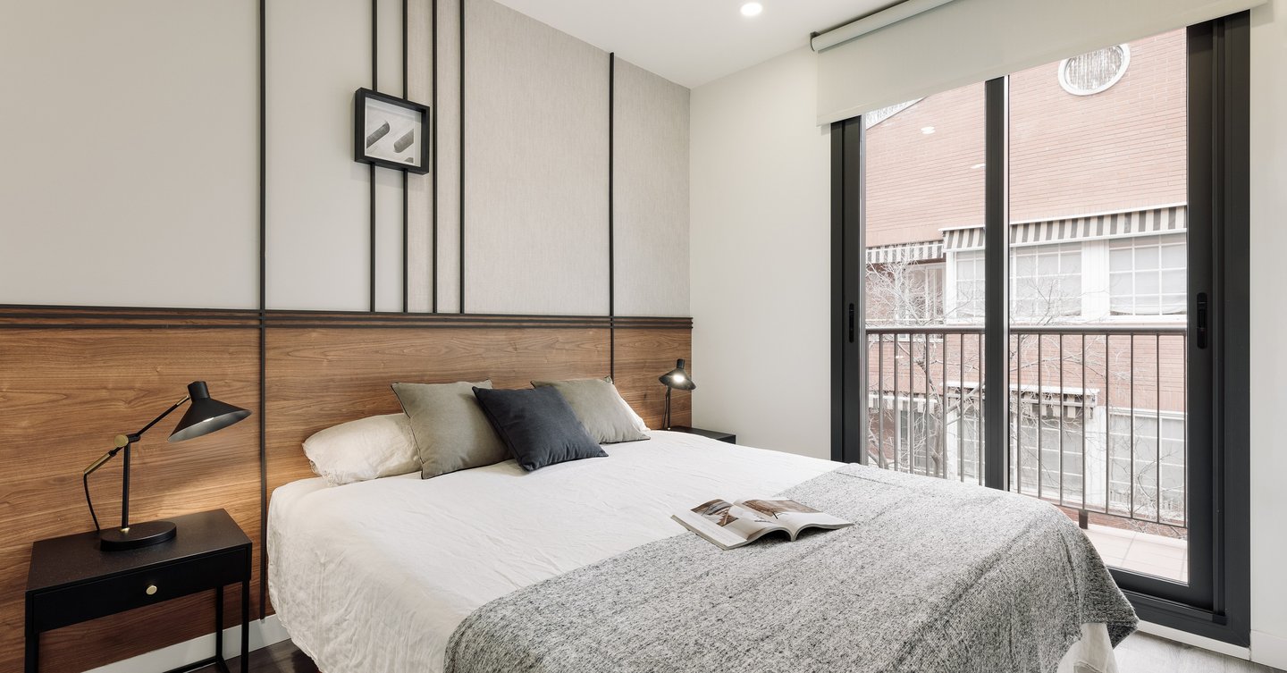 Sophisticated bedroom with natural walnut finishes, custom art pieces, and balanced design by SAVIA