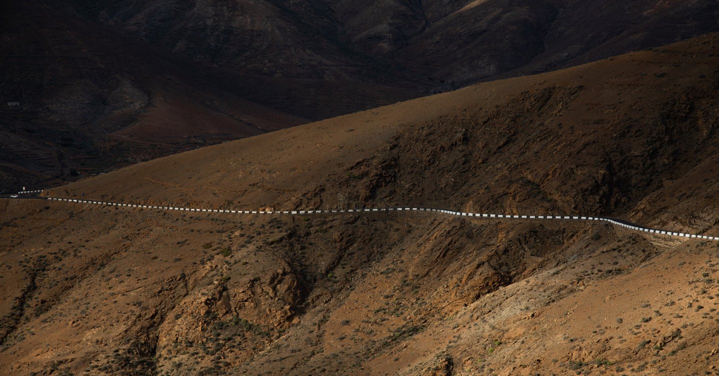 a long line of cars driving down a mountain