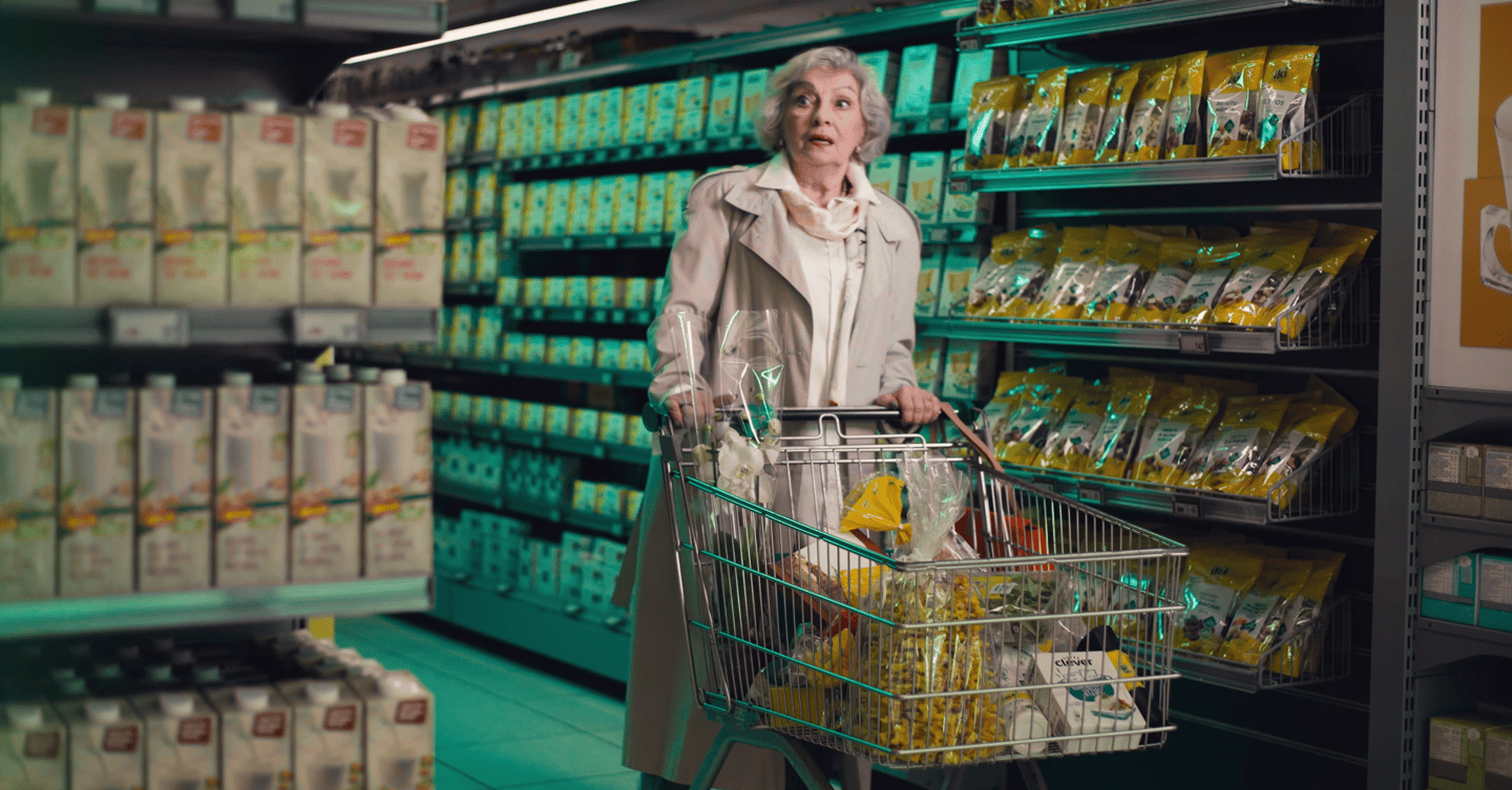a woman in a white coat is holding a shopping carton