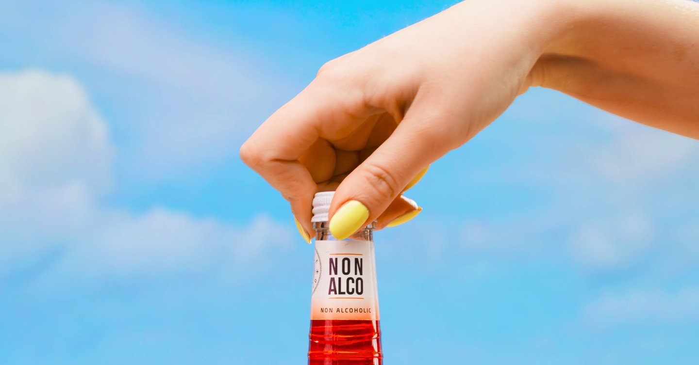a person holding a bottle of alcohol in a bottle