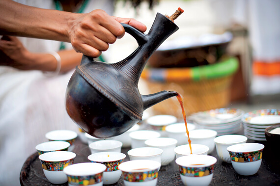 a person pouring coffee into cups in Ethiopia coffee ceremmey