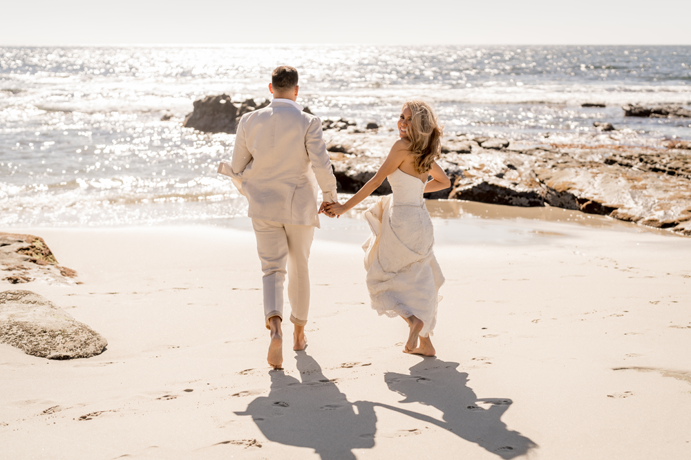 newlywed couple running on the beach in La Jolla , California