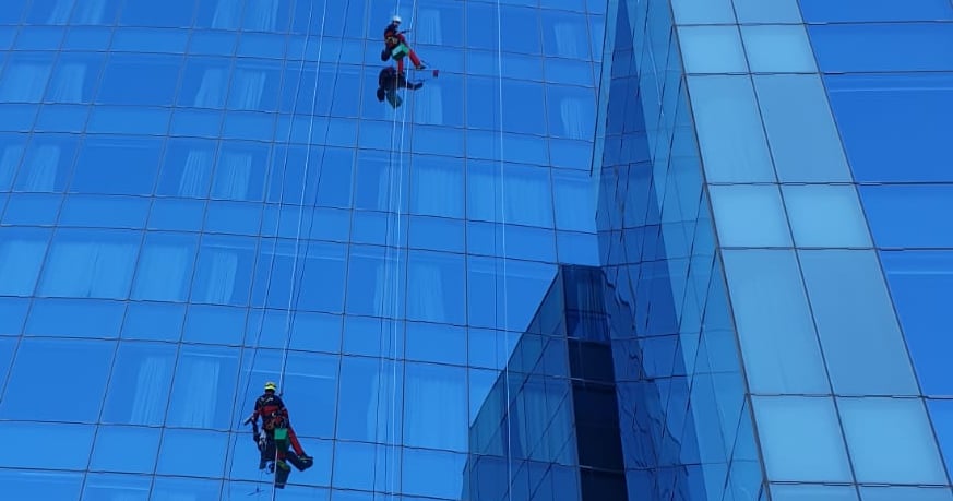 Two men hanging from a high riser