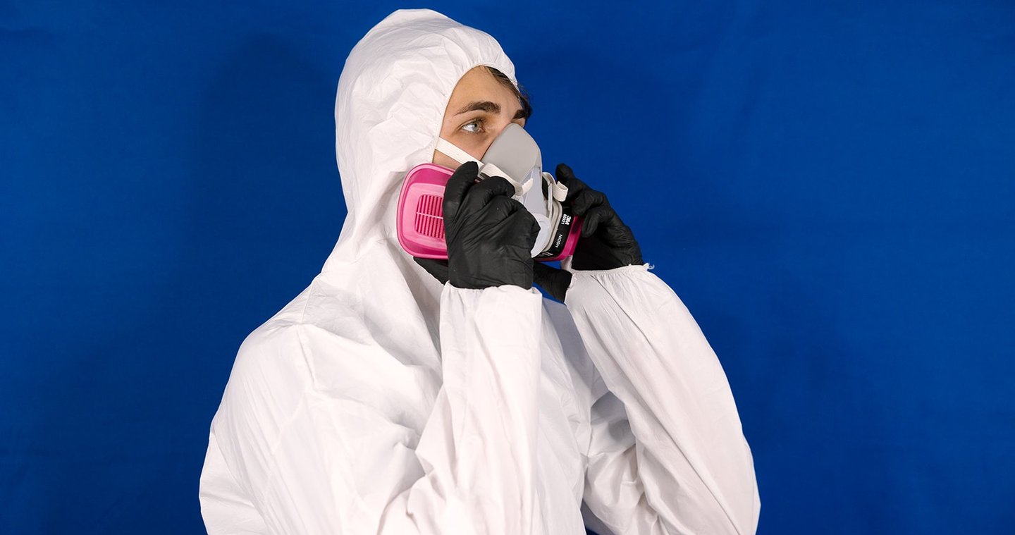 a man in a white suit and a pink respirator