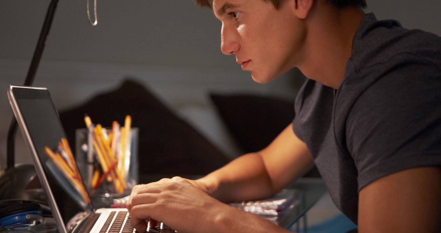 imagem mostra um jovem estudando com seu notbook. 