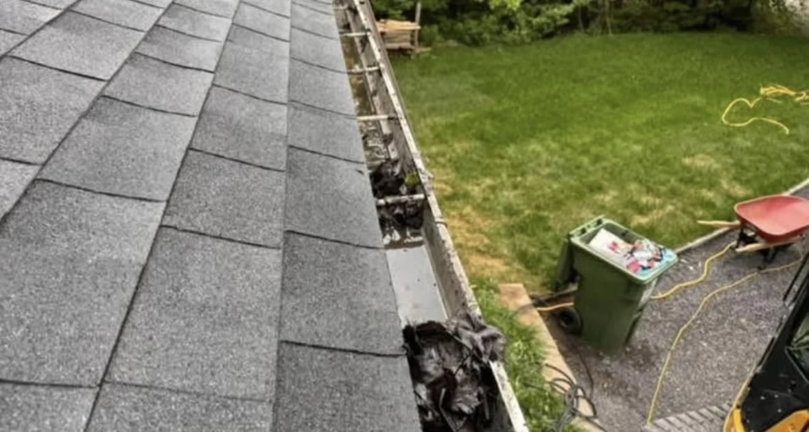 Gouttières pleines de feuilles entrain de se faire déboucher