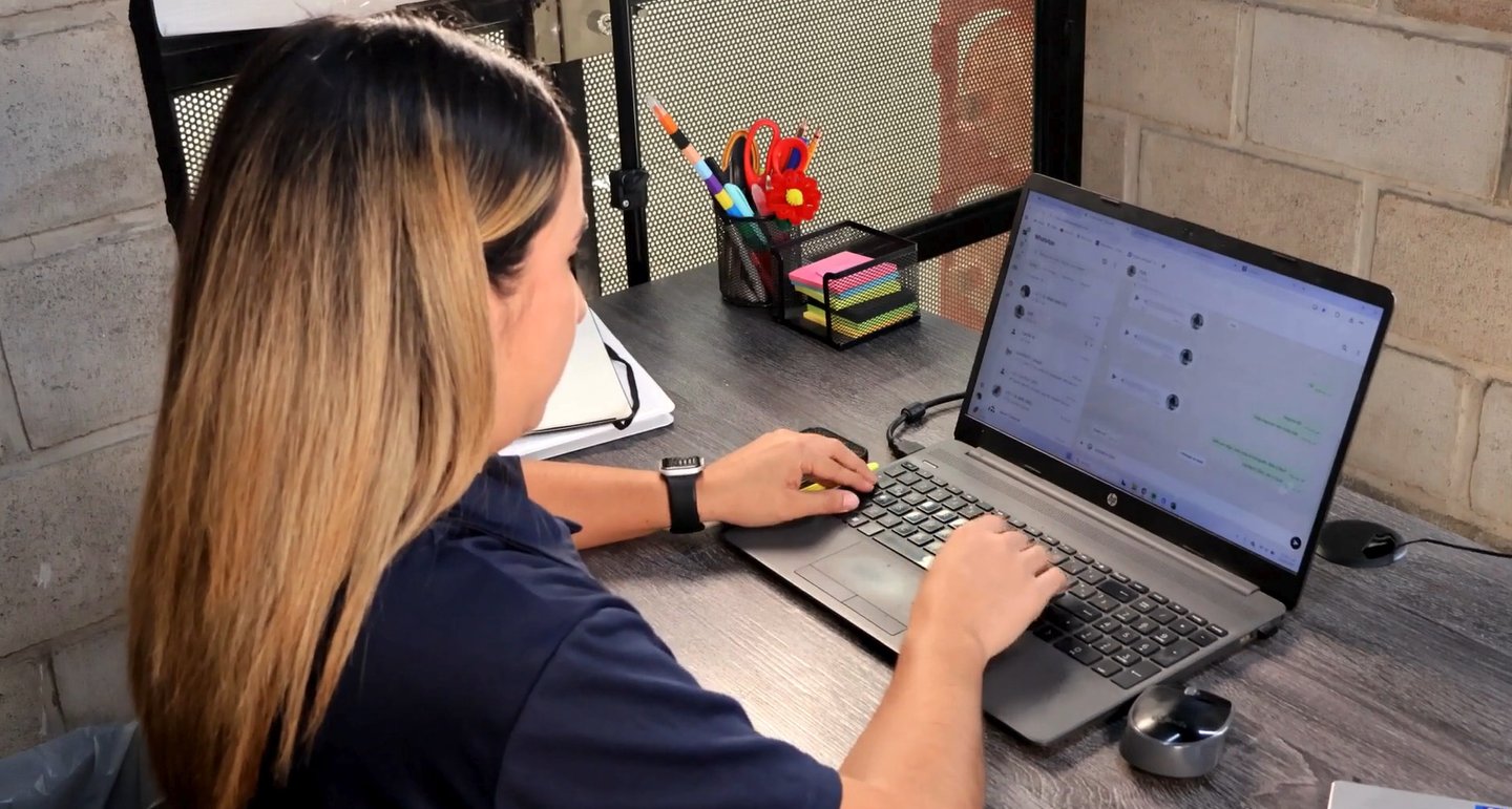 a woman sitting at a desk with a laptop computer