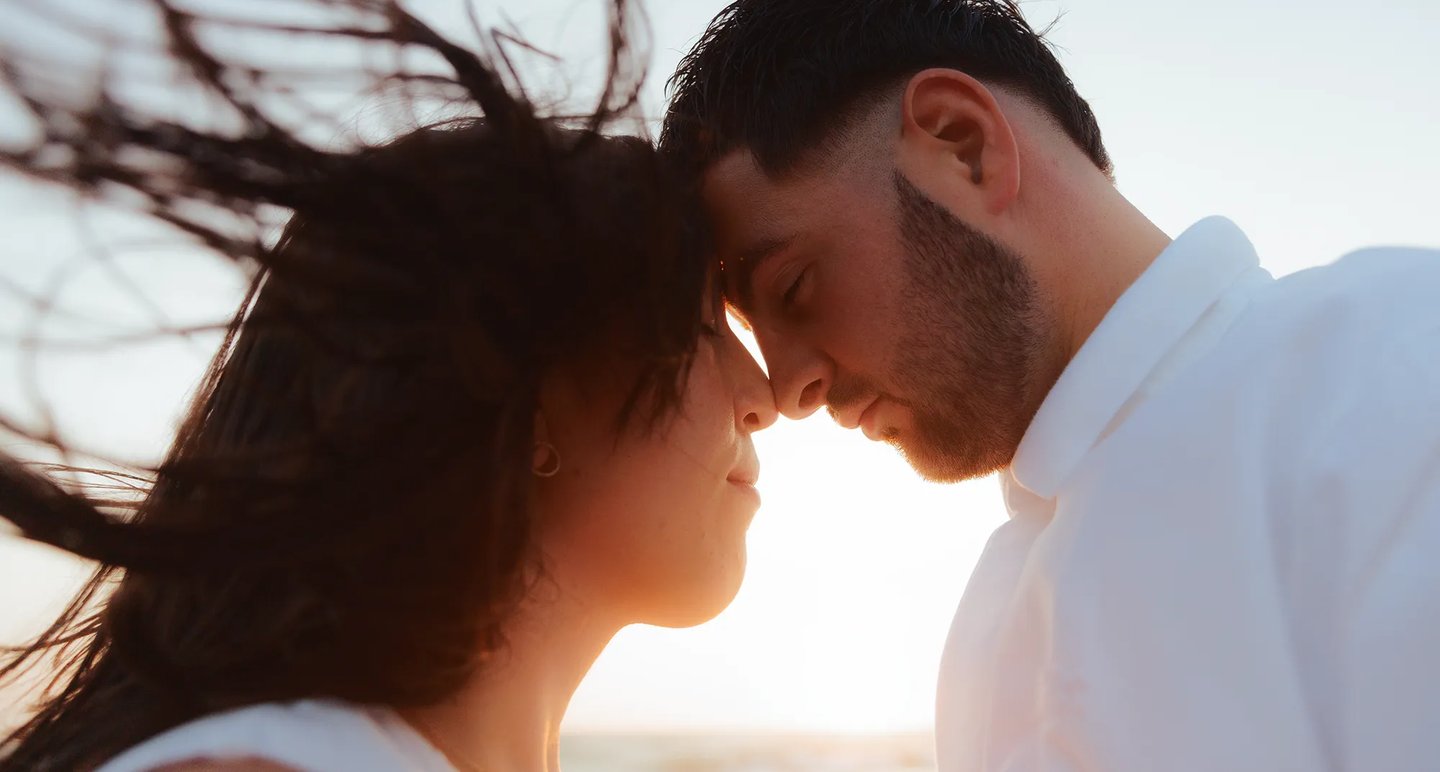 Photographie intimiste d'un couple au coucher du soleil pendant la golden hour sur la plage de Sauveterre en Vendée