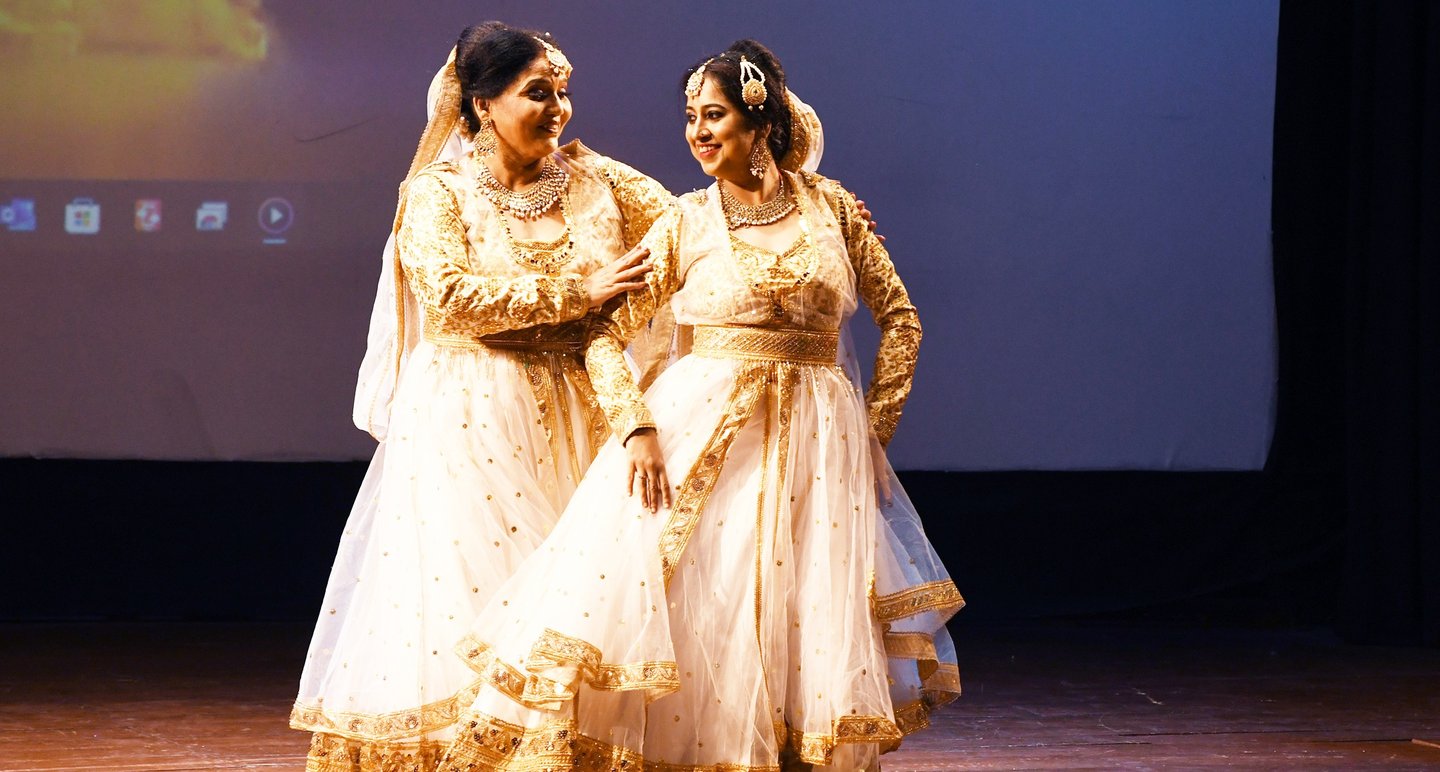 Mrs. Chaitali Biswas gracefully performing a kathak dance in traditional attire on stage.