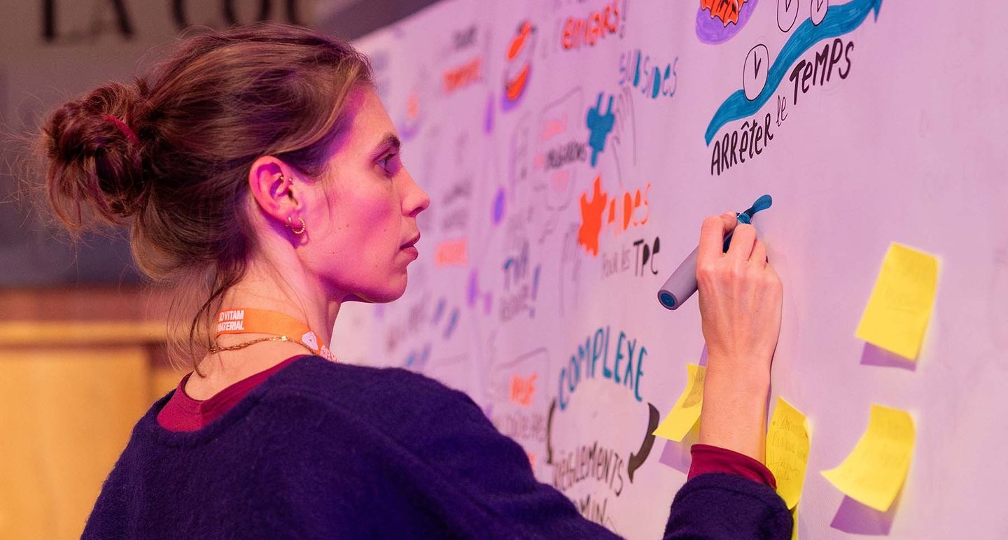 a woman is writing on a white board