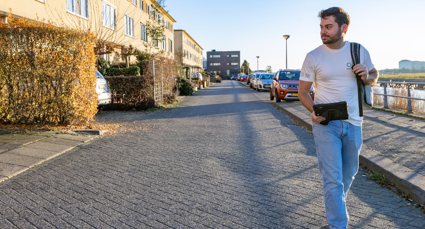 Eigenaar OG Vastgoed loopt door woonstraat naar klant voor energielabel en vastgoedfotografie
