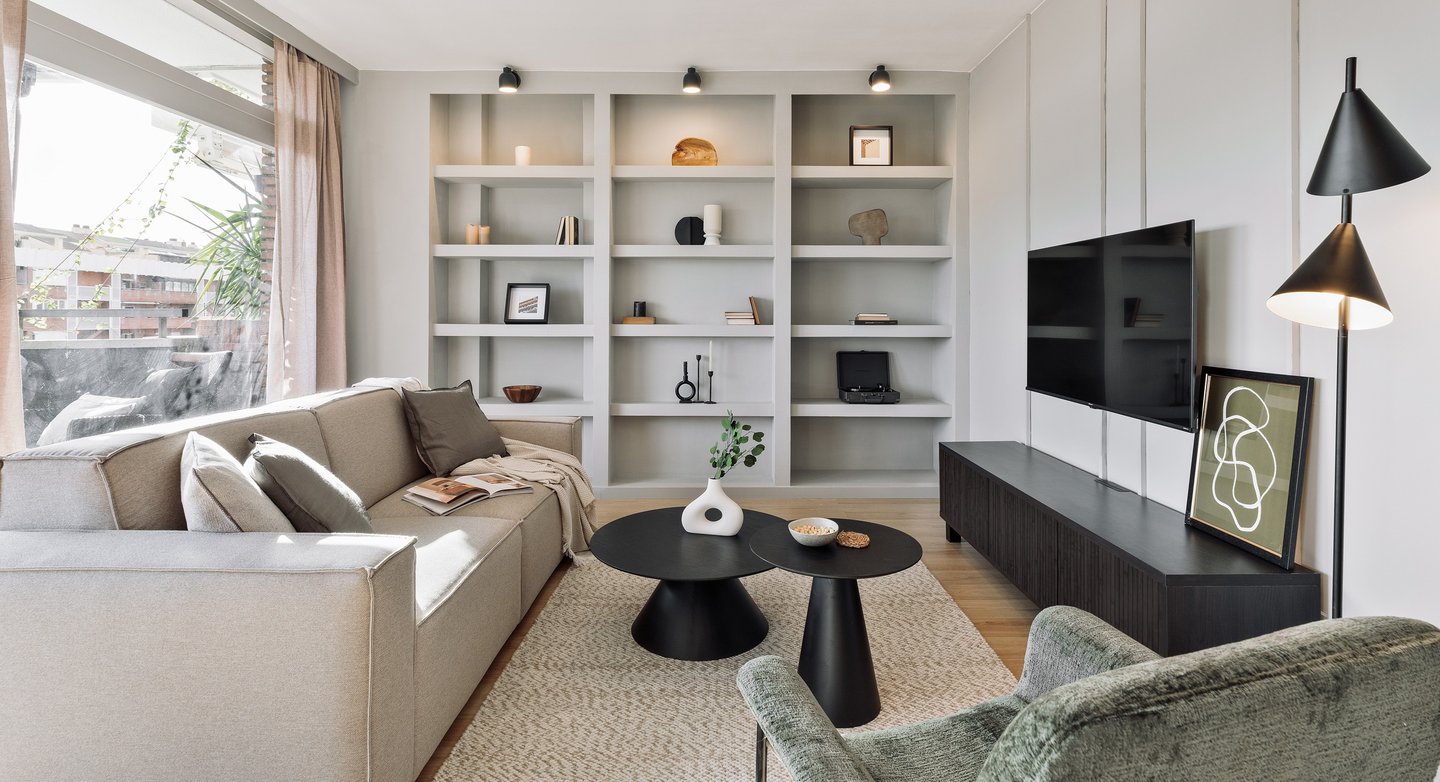 Elegant living room with contemporary furniture, neutral tones and custom bookshelf