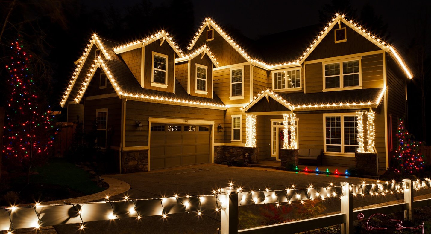 a house with christmas lights on a fence