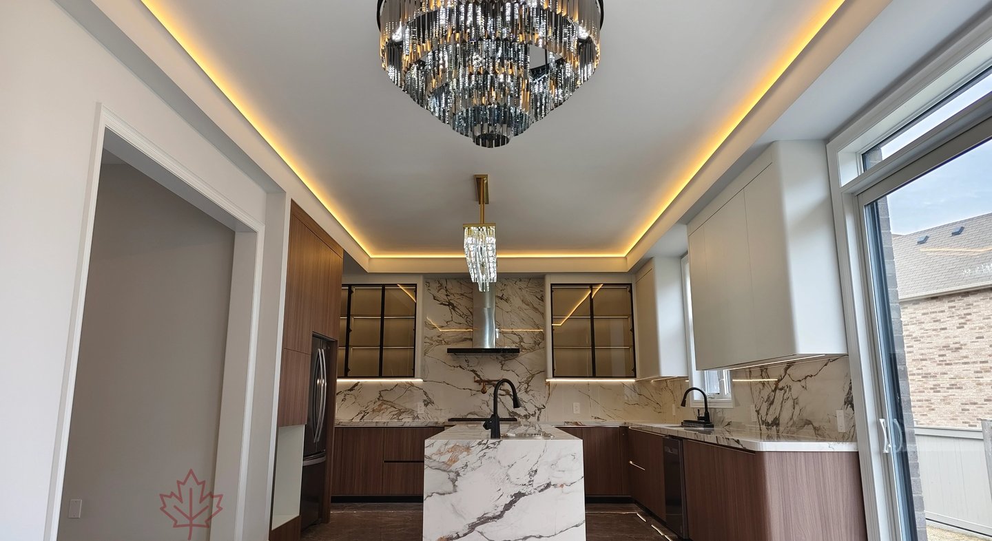 Luxury modern kitchen completion featuring a massive Calacatta marble waterfall island, custom wood 