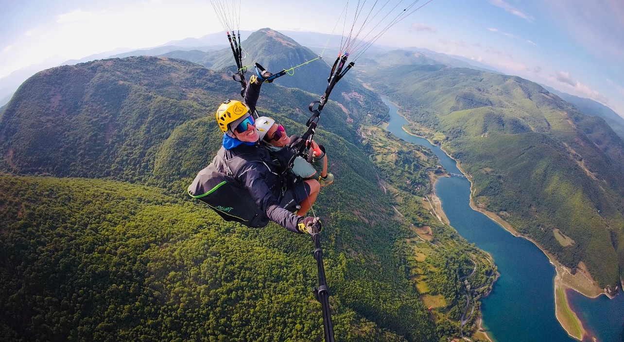 Volo in parapendio biposto sopra la Valle Reatina, esperienza outdoor con vista su lago e montagne vicino a Rieti