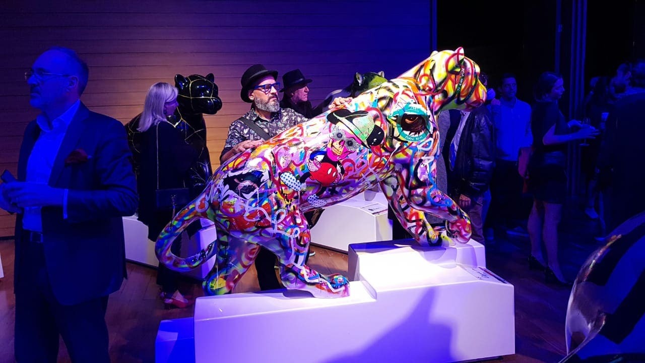 Uma imponente escultura de onça-pintada decorada com colagens