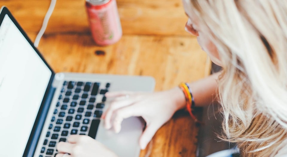 Frau, die am Schreibtisch vor dem Computer sitzt