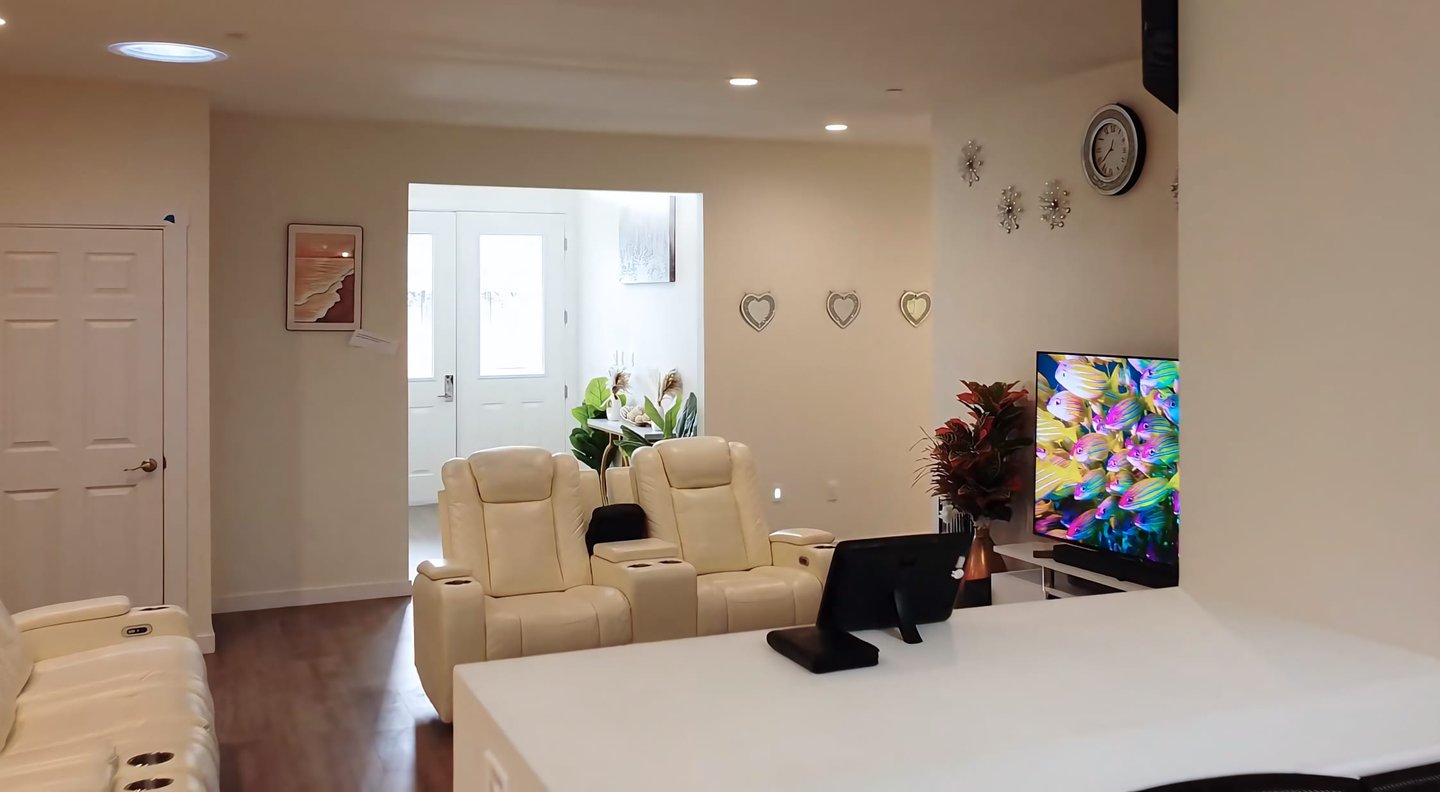 Cozy living area at Holistic Haven (AFH) with comfortable sofas, large TV, and warm, home-like decor for residents.