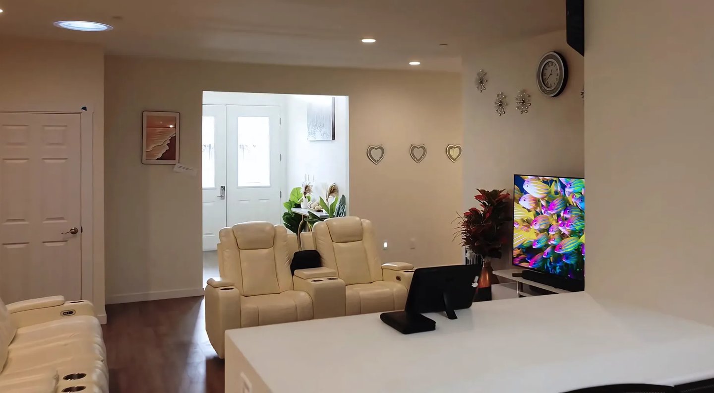 Cozy living area at Holistic Haven (AFH) with comfortable sofas, large TV, and warm, home-like decor for residents.