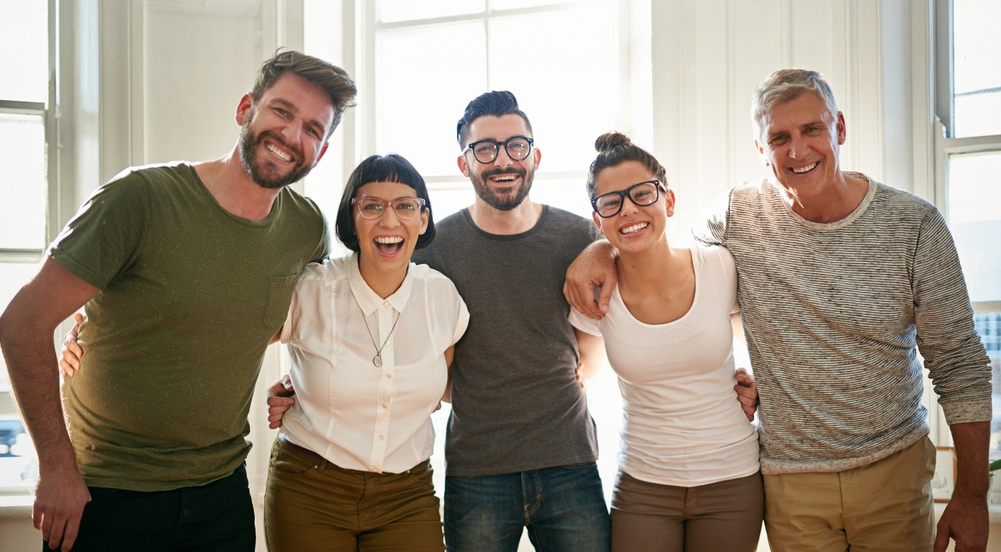 a group of people standing for a team photo showcasing the dynamic of the company