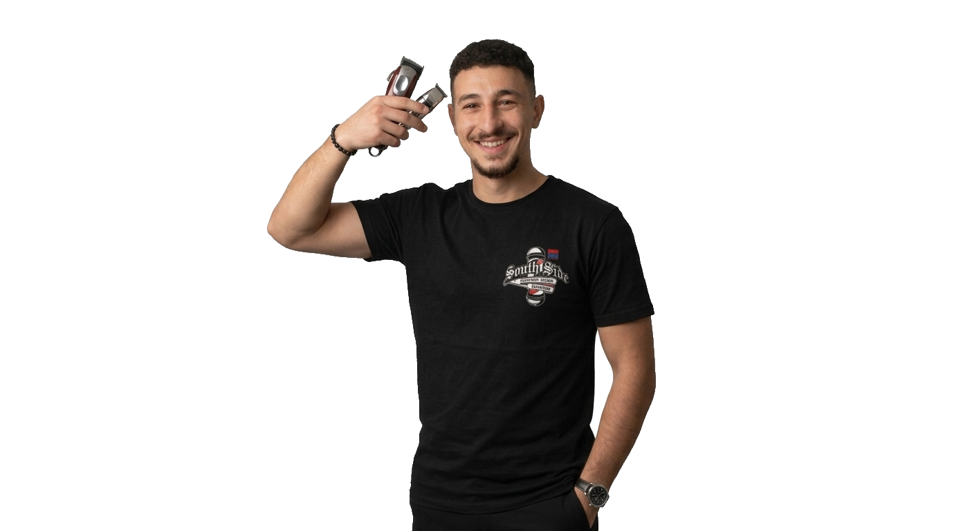 Smiling male barber in a black t-shirt holding professional hair clippers and grooming tools.