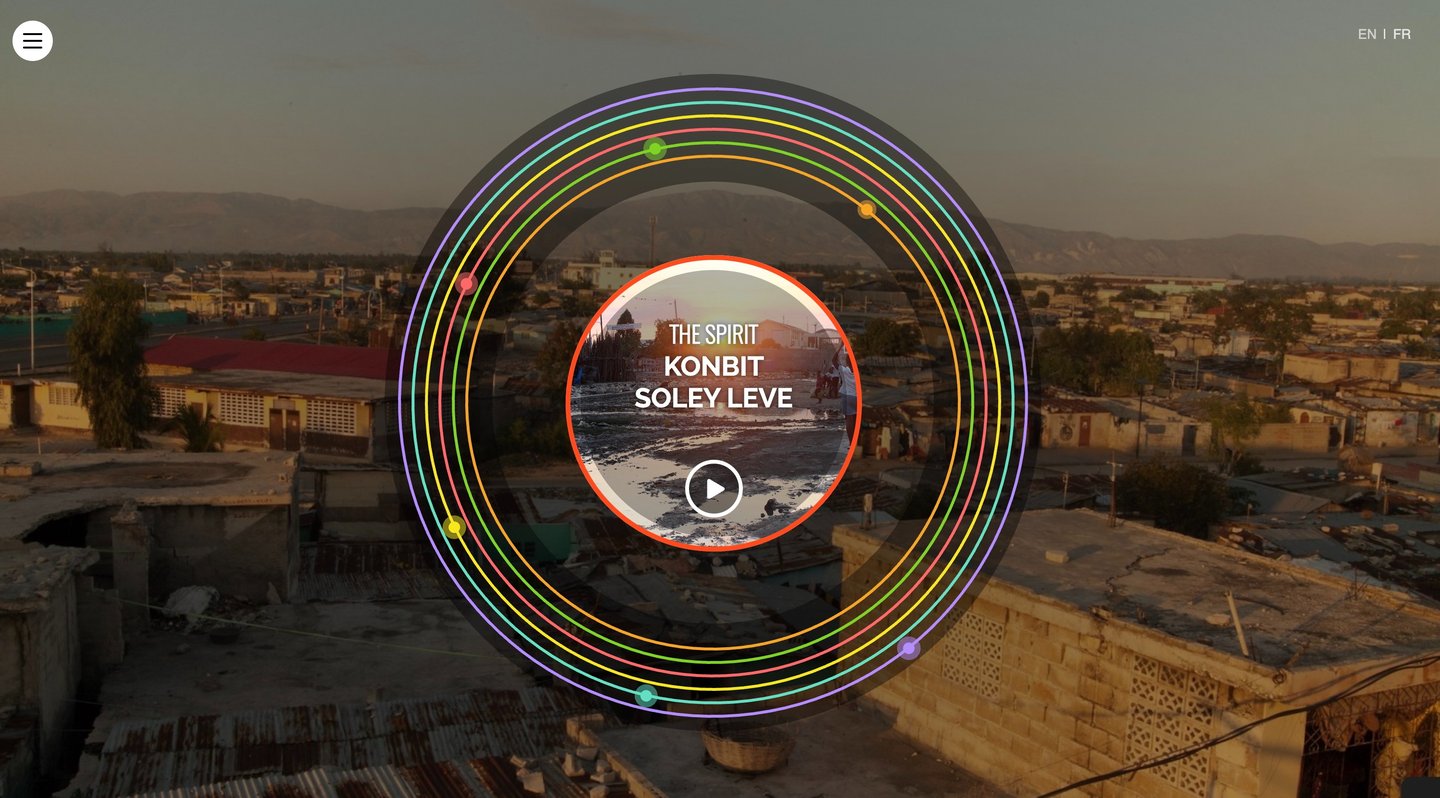 Site web avec cercles colorés ; texte : « The Spirit: Konbit Anba Soley » avant le coucher du soleil