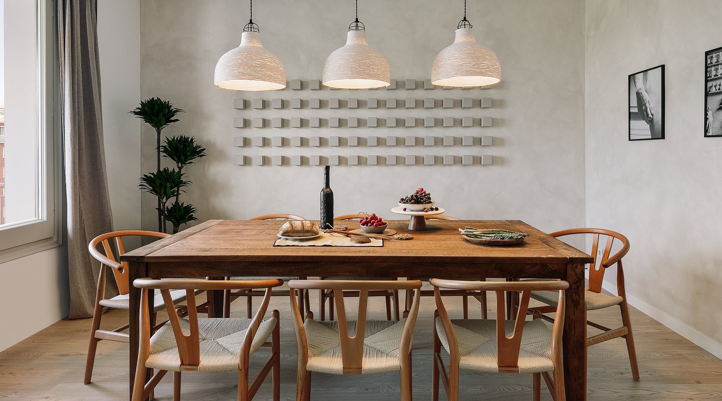 Dining area with elegant decor, wooden table and chairs, custom lighting and calming design by SAVIA