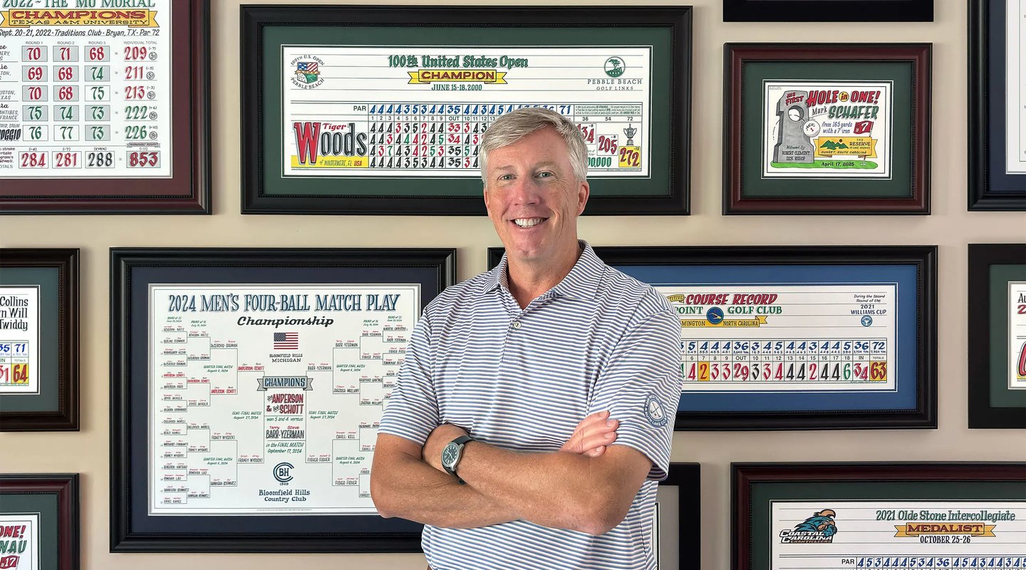 Casey standing in front of a wall of his colorful golf artwork.