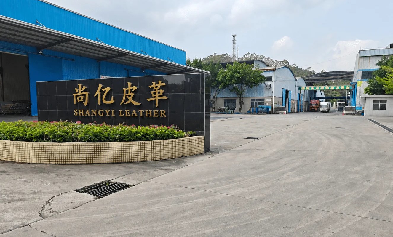 Shangyi Leather manufacturing facility entrance with a modern black stone sign and industrial buildings.