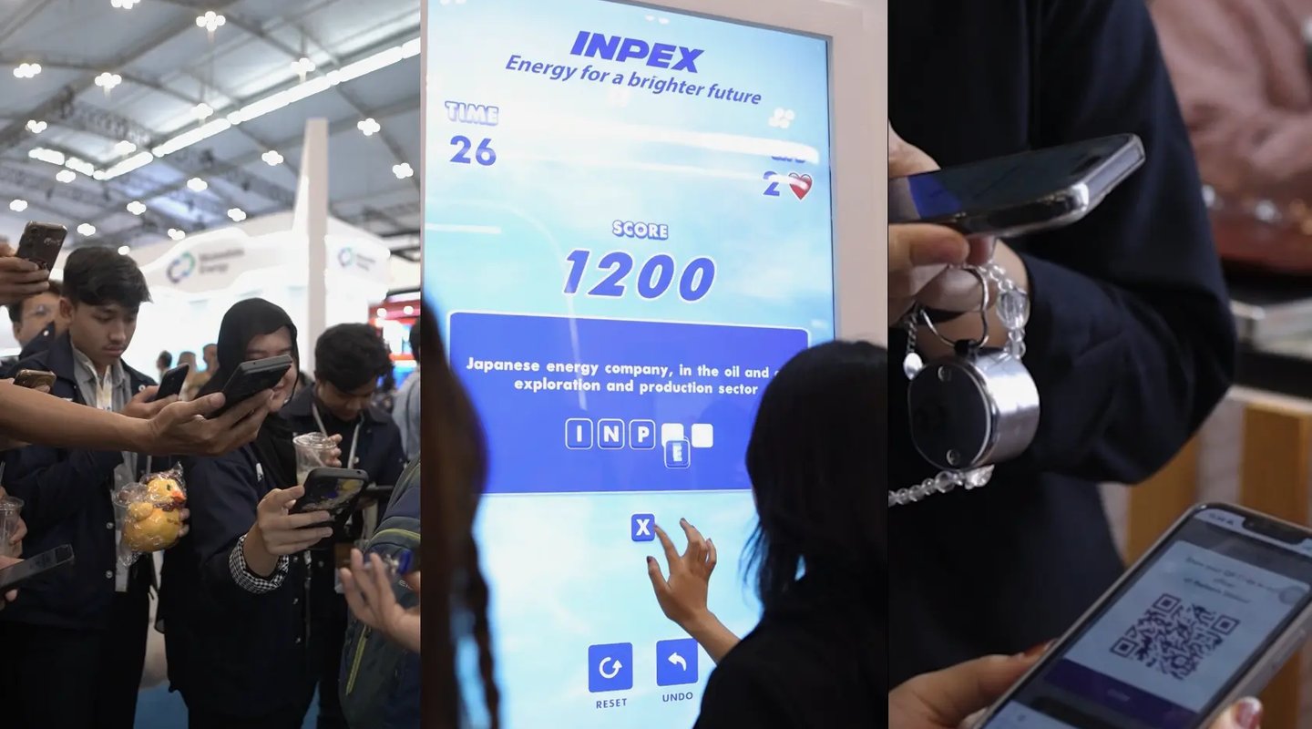 isitors interacting with large touchscreen games at INPEX exhibition booth