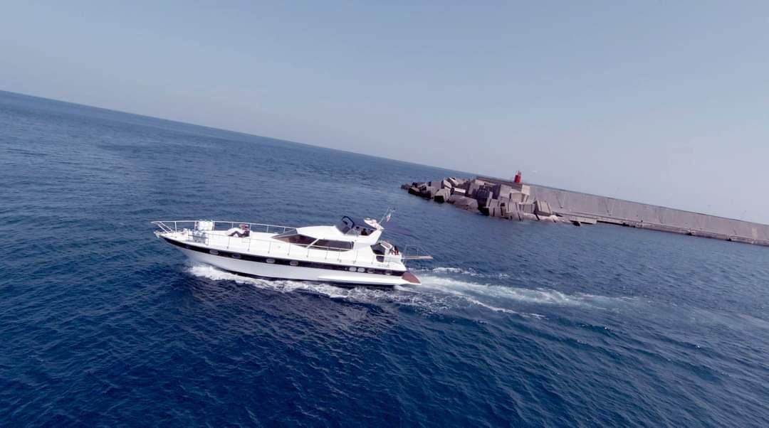 a boat in the water with a lighthouse in the background