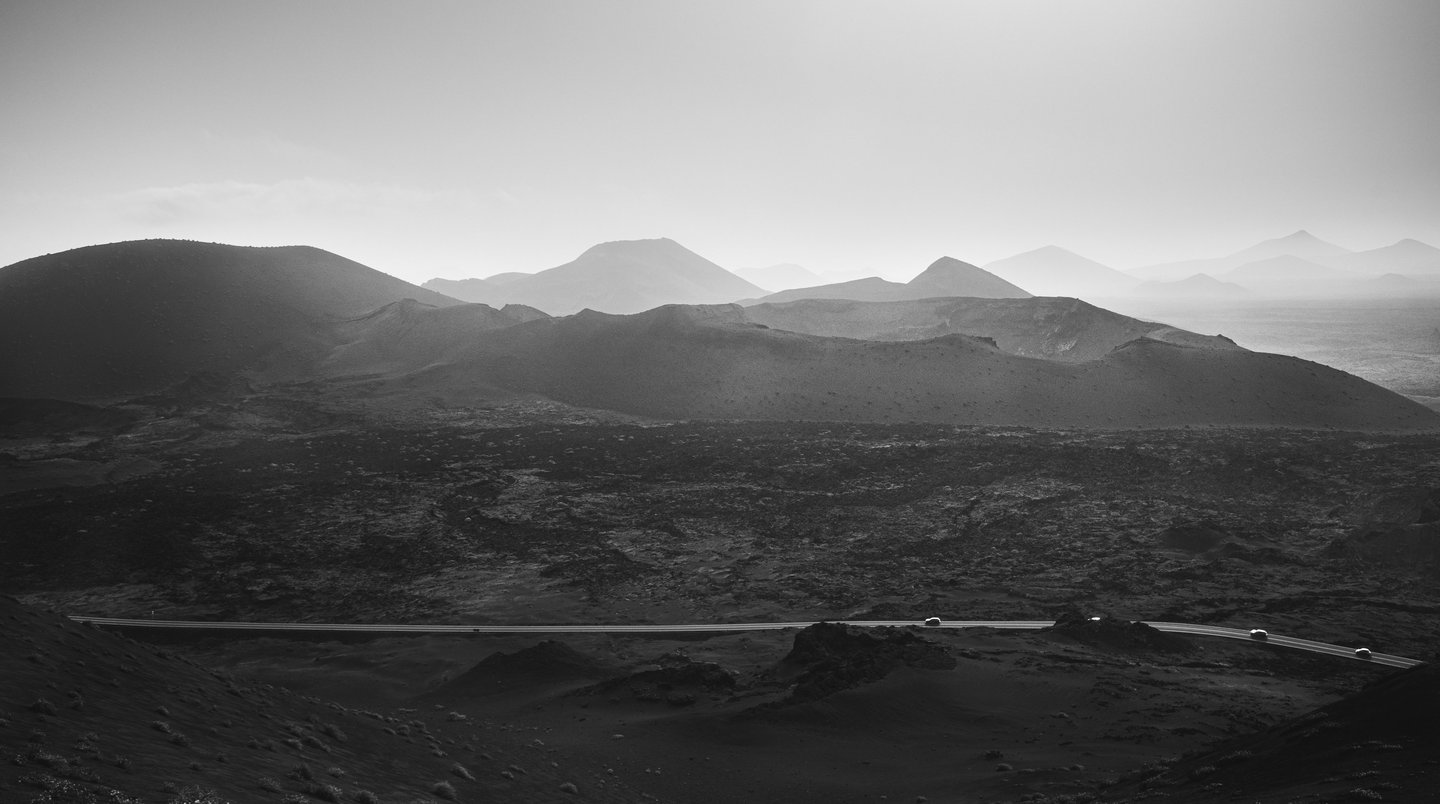 a mountain scene with a road and a car
