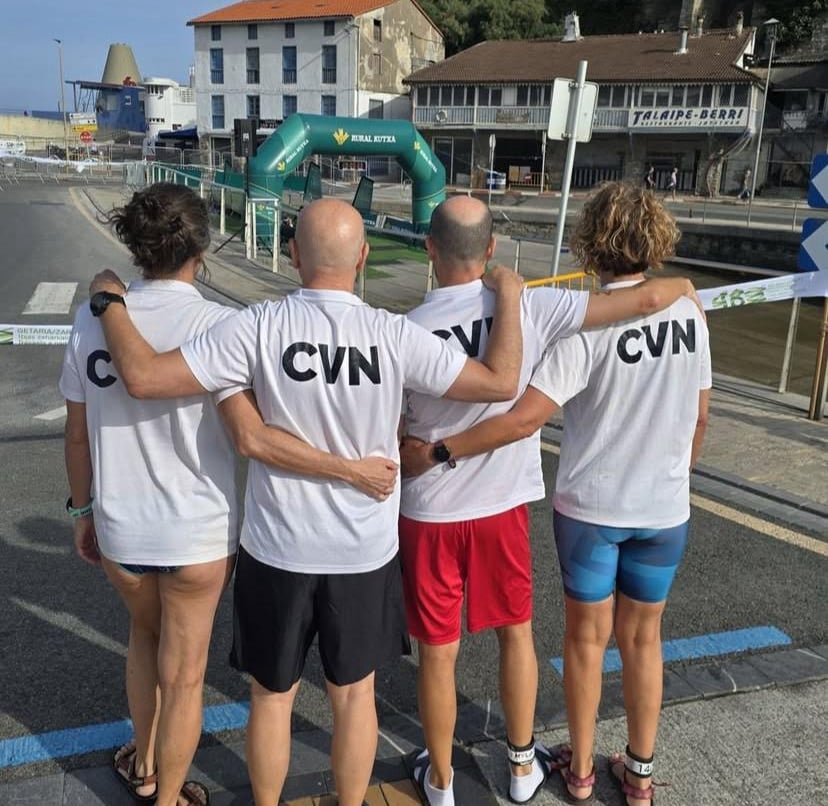 Equipo master de triatlón posando para una foto con el polo del club