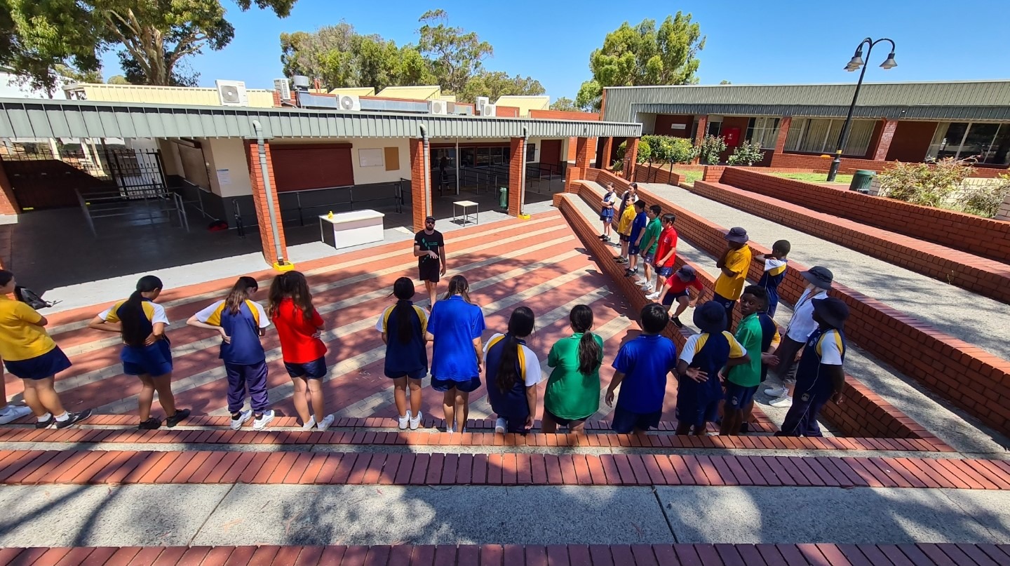 a group of children and adults standing in a line learning life skills