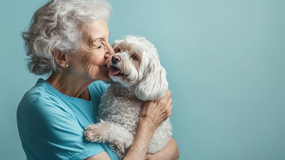 Elderly women kissing her dog.