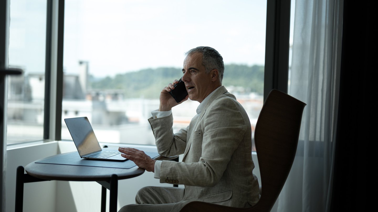 a man sitting at a table with a laptop and a laptop