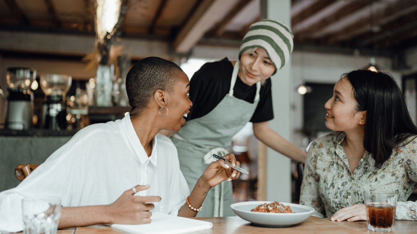 a woman is standing in front of a man in a restaurant
