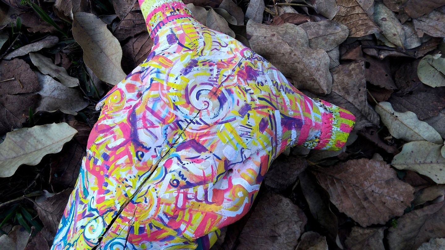 peinture aux couleurs vives sur un crane  sur un lit de feuilles mortes