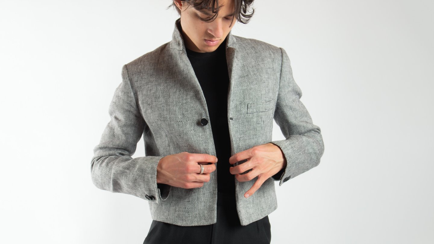 A man in a grey tweed jacket for a stylish fashion look.