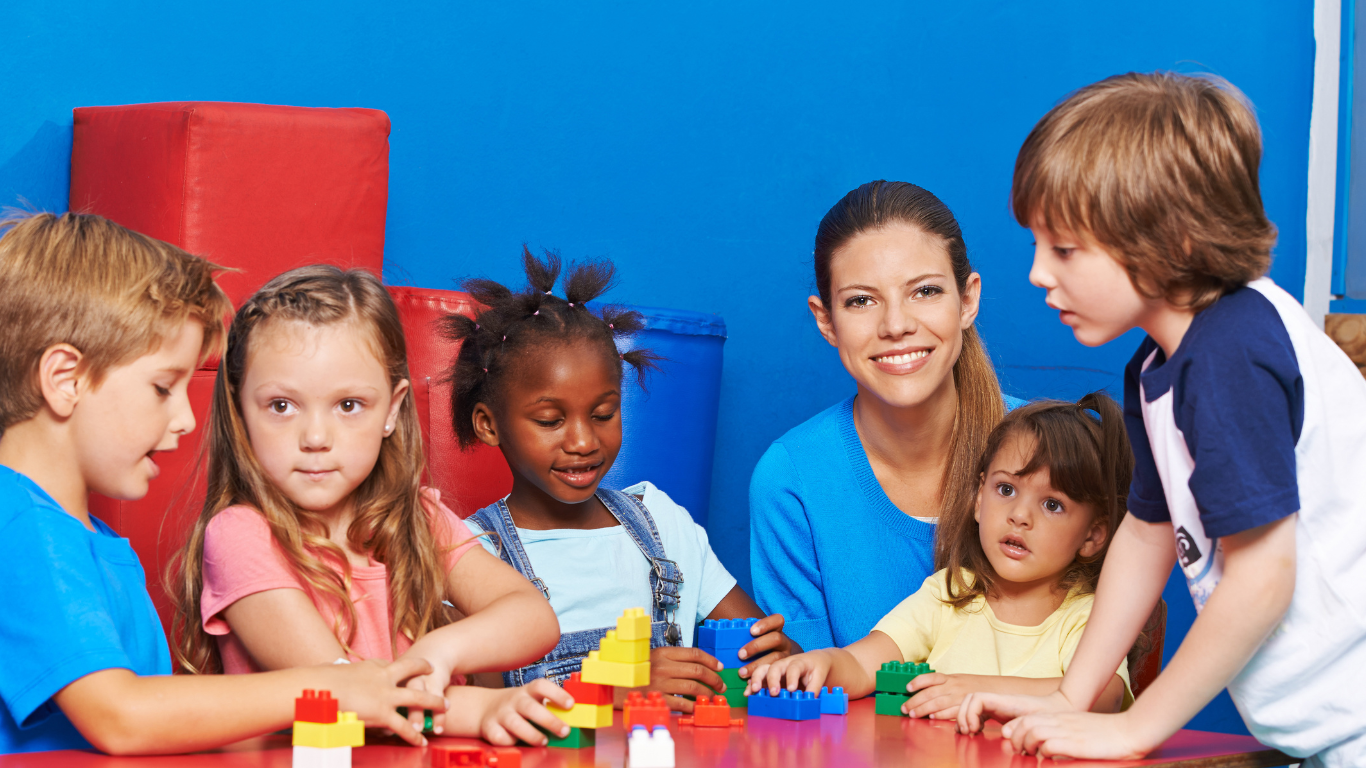a woman and children playing with blocks on a table