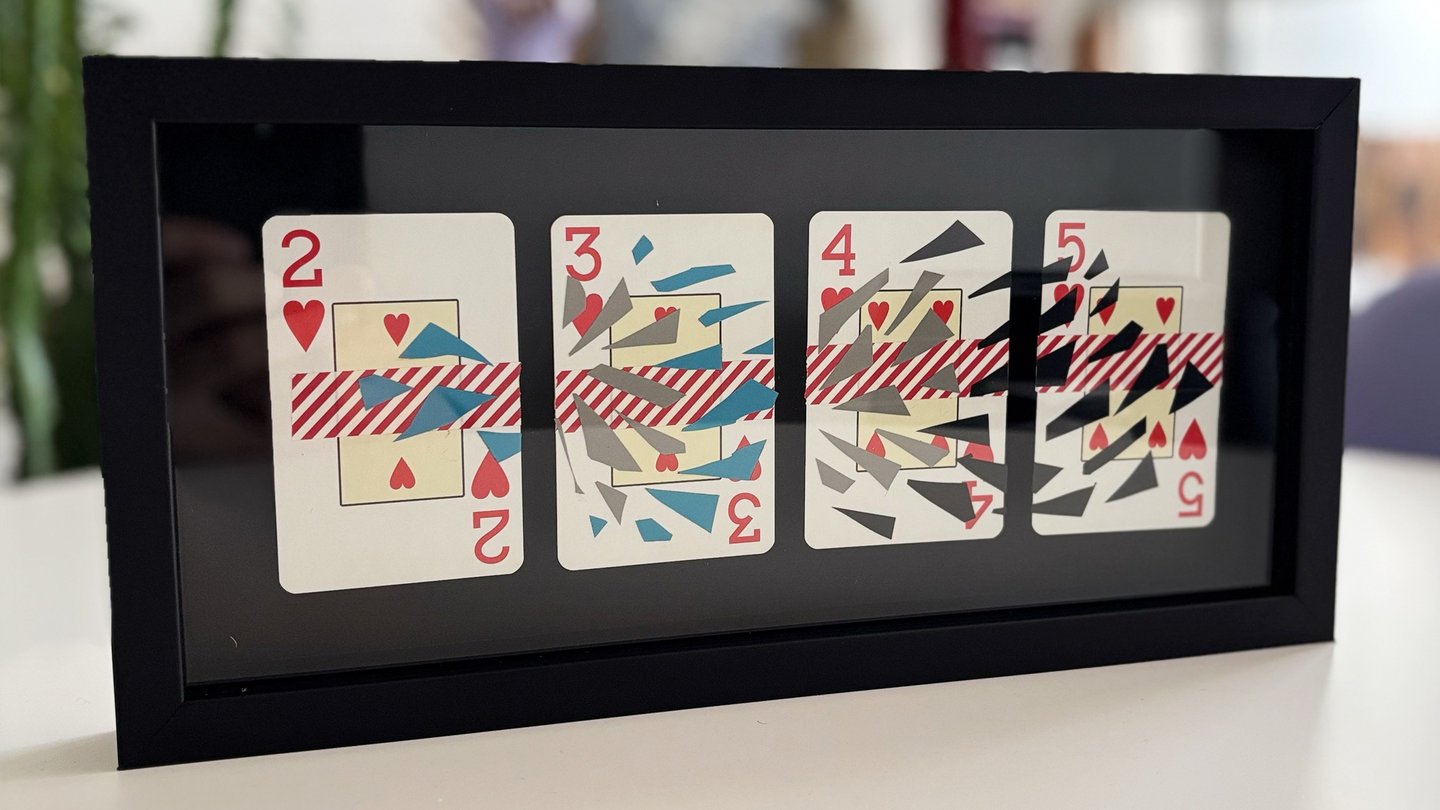 imagem da obra, composta por 4 cartas de baralho com intervenções de washi tape e fita isolante, emolduradas com fundo preto.