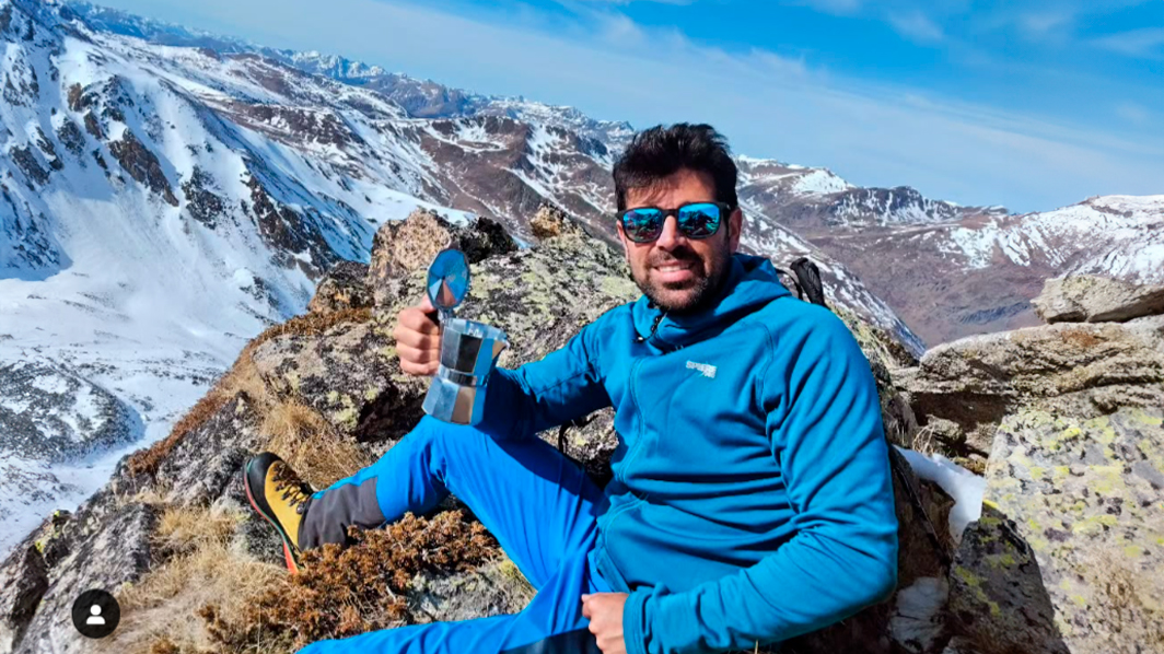 guía de montaña con una cafetera en la cima