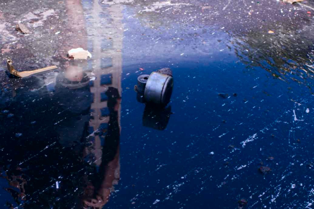 a fire hydrant sitting in the middle of a puddle