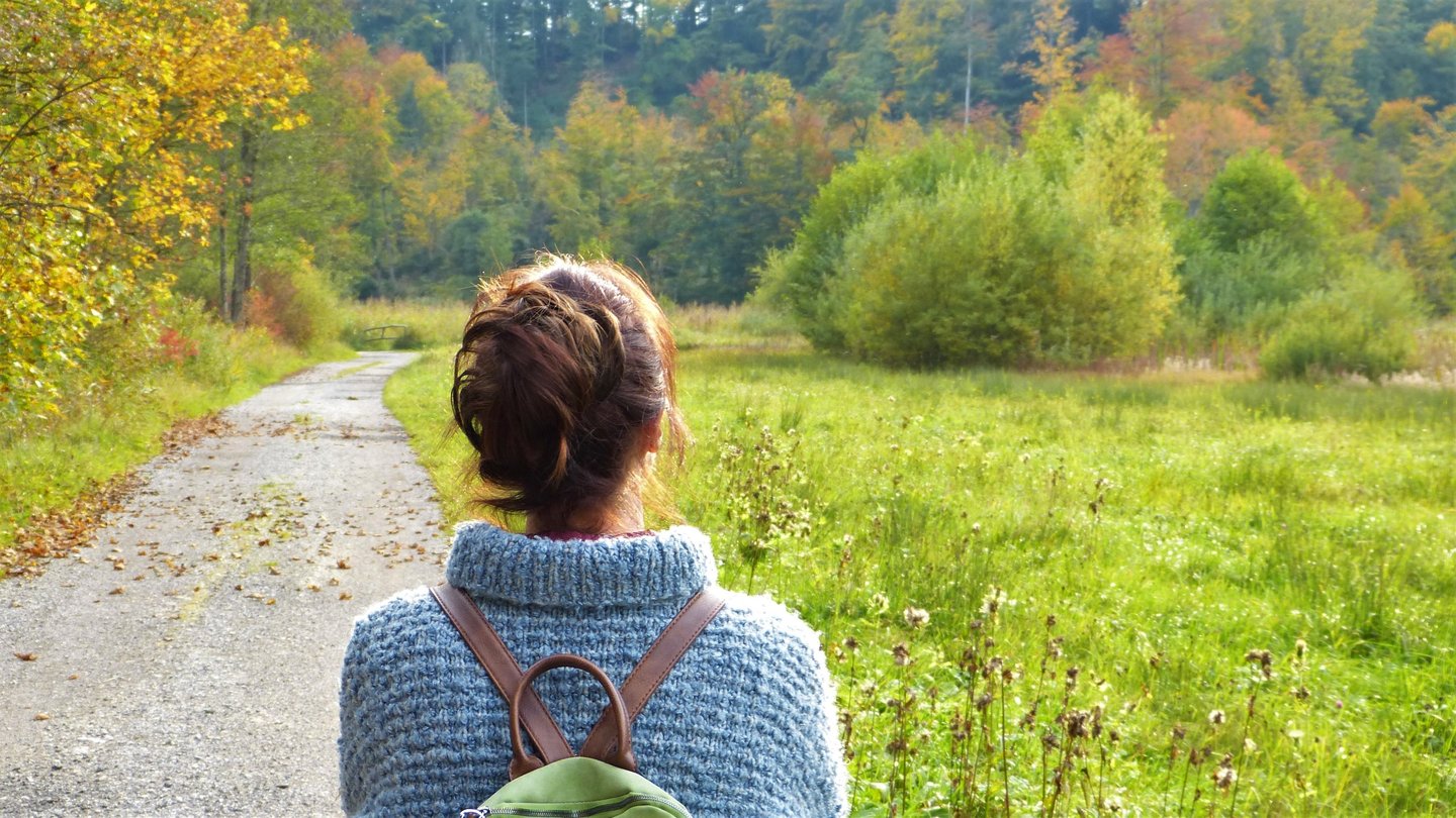 Femme de dos se promenant dans la nature.